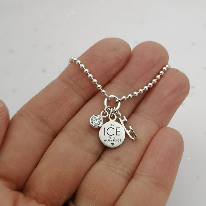 Happy Place Silver Ice Charms Bracelet being held in a hand on a white background