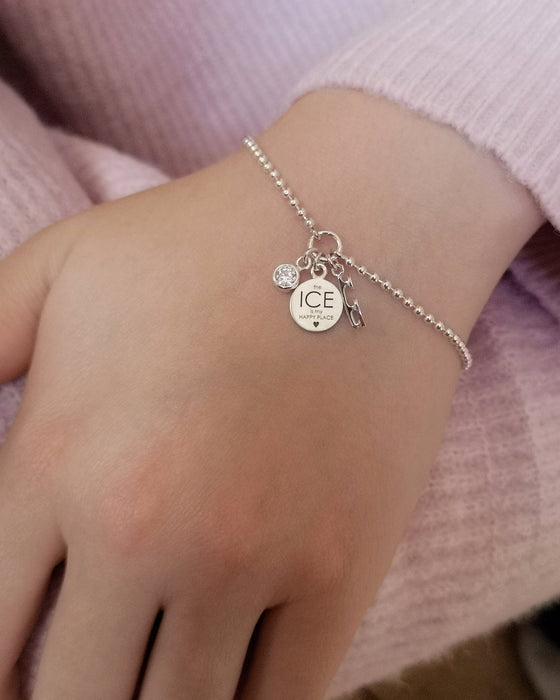 Ice Skating ball chain bracelet with three silver charms, a skate blade, disc with an engraved motto and a sarkly charm being worn on a wrist