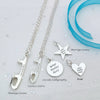 Silver necklaces with customizable ice skate blade pendants on a light gray background