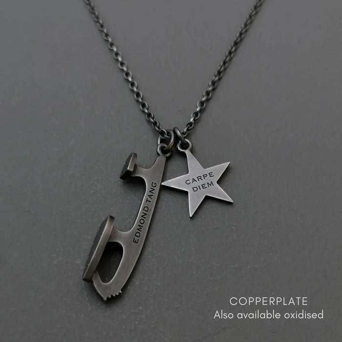 Personalised necklace with an ice skate  blade and star charm on a gray background
