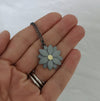 hand holding an oxidised silver dahlia necklace