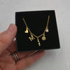 Gold necklace with charms held in a black box