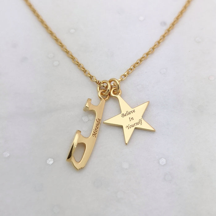 gold ice skate blade and star necklace on a grey sparkly background