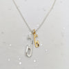 Necklace with two pendant charms on a light gray background