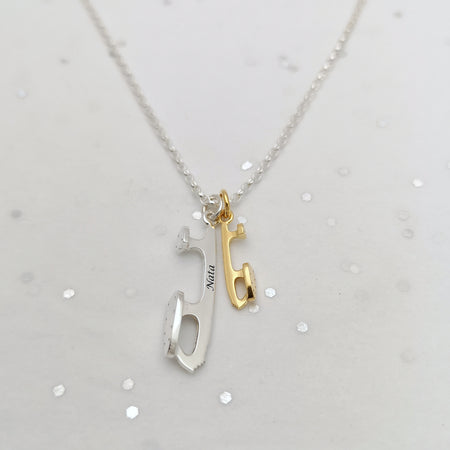 Necklace with two pendant charms on a light gray background