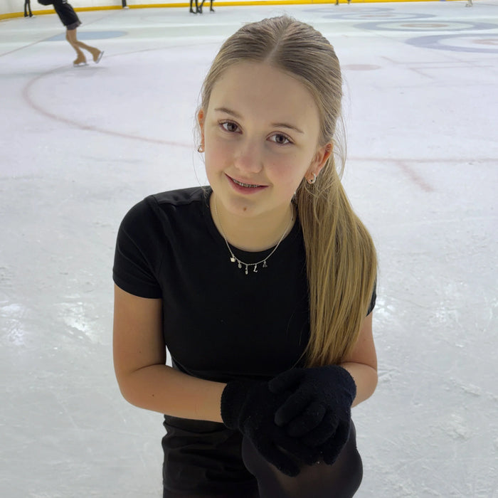 Young girl in a black outfit on an ice rink