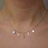 silver necklace with five ice skating charms on a model