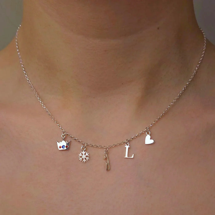 silver necklace with five ice skating charms on a model