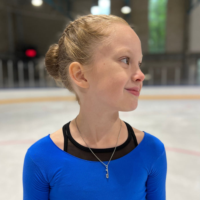 silver ice skating necklace being worn by a figure skater on the ice