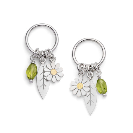 a pair of botanical earrings with daisies and leaves and green periots, on a white background