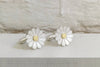 silver and gold daisy cufflinks on a white background